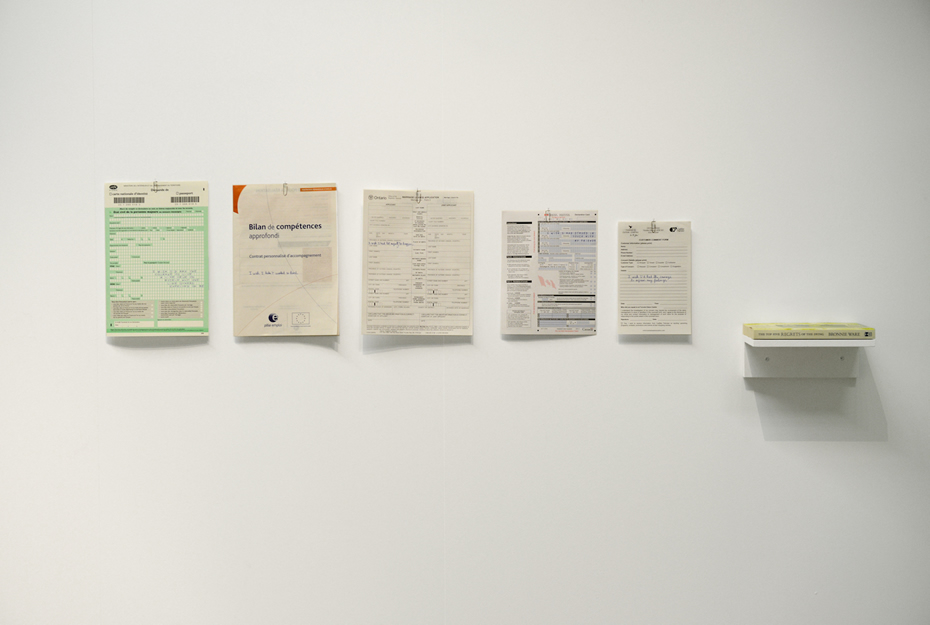 The Top Five Regrets of the Dying, 2013 Écritures au fineliner bleu sur 5 documents franco-canadiens Installation : documents, trombones, livre sur étagère, dimension variable Crédit photo : F. Gousset (vue d’exposition du 58ème Salon de Montrouge, 2013)