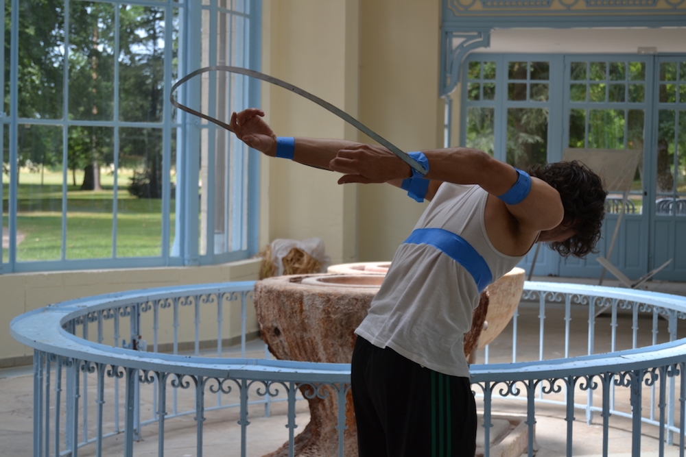 Flora Bouteille, It’s just mental, l’homme de paille, 2019 Blé, bois, ouate, aimants de trottinette Lime, raphia, combinaison delta plus, performer Performance 20 min en fonction de la chaleur Dimension variable Pan toxic trajectories (siporex / verre fondu au micro-onde) réalisé en collaboration avec Victor Villafagne