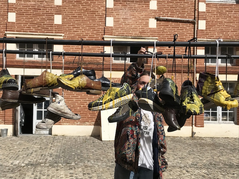 Carla Lloret Palmero, Stand de cirage de pompes, 2021. Cire, paires de chaussures. 350x70x170cm Photographie lors de la performance.