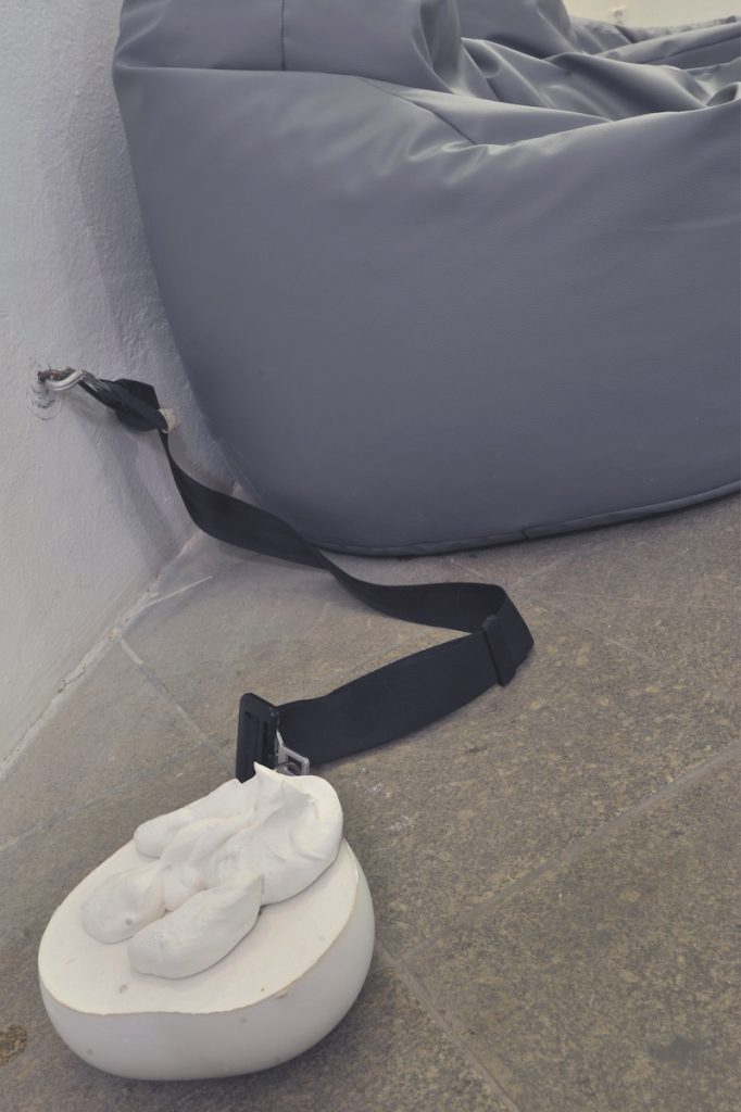 Veronika Olejárová: Fasten your seatbelts! Detail of an installation, 2023. Carpet, fatboys, winding mechanism for car seatbelts, plaster object. Photo: Pavel Petrov, OGV Jihlava.